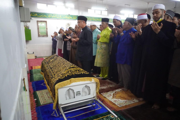 阿德里（前右）在清真寺在母亲棺木前祈祷。次排右5为甲州元首敦莫哈末阿里。