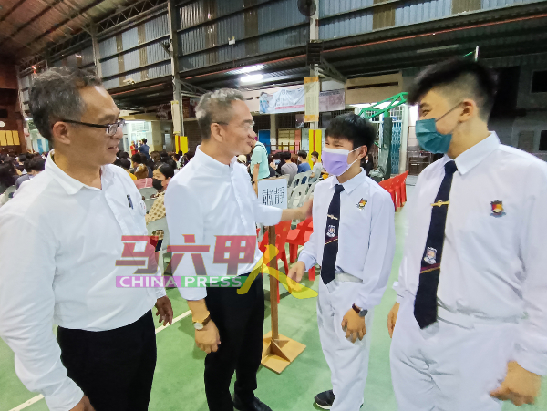 邱培栋（左2）在刘志俍（左）陪同下，与公教中学学生交流。