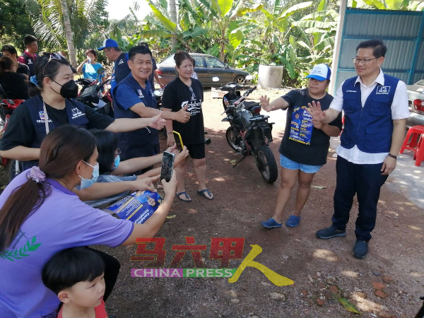 林千宏（前排左3）陪同林万锋到阿依沙叻新村，与选民交流。
