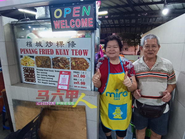 炒粿条华裔夫妇小贩温春德（右）与黄春莲已与马来顾客及穆斯林小贩打成一片，关系犹如家人。