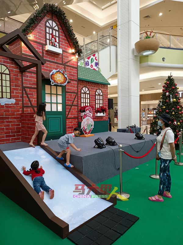 ■各族小朋友迫不及待，在永旺购物广场（甲市区）的圣诞节布景滑梯进行游戏。
