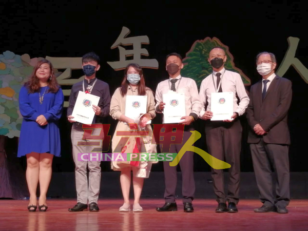 服务10年的教师领取服务奖。左和右是黄雪莱与萧汉昌。