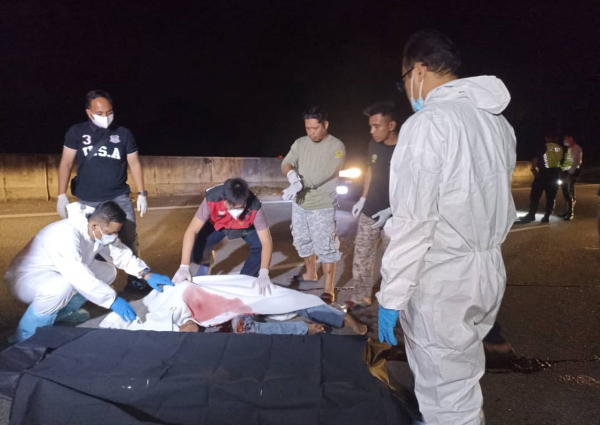 警方在医务人员及路人协助下，把死者遗体移上担架，以送往太平间解剖。