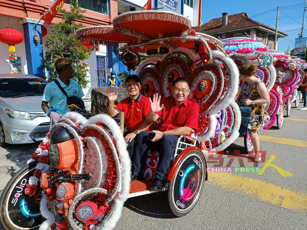 配合甲州旅游促进局在鸡场街拍摄新年宣传影片，众人乘坐三轮车，右起颜天禄及李传财。