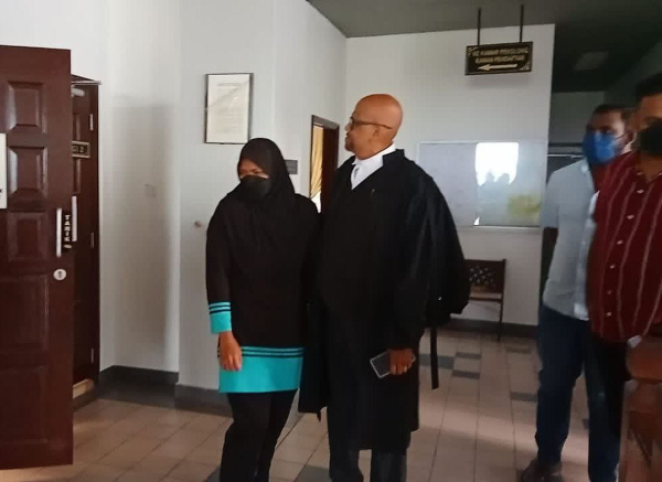 获释的努鲁莎琪拉（左），在庭外等候法庭对丈夫的裁定消息。