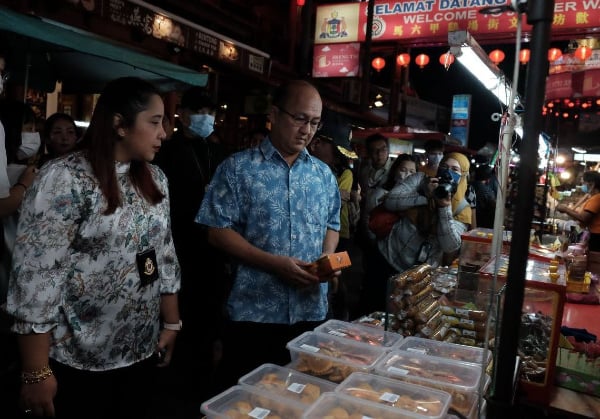 魏喜森（左2）到鸡场街巡视商品标价情况，左为诺丽娜。