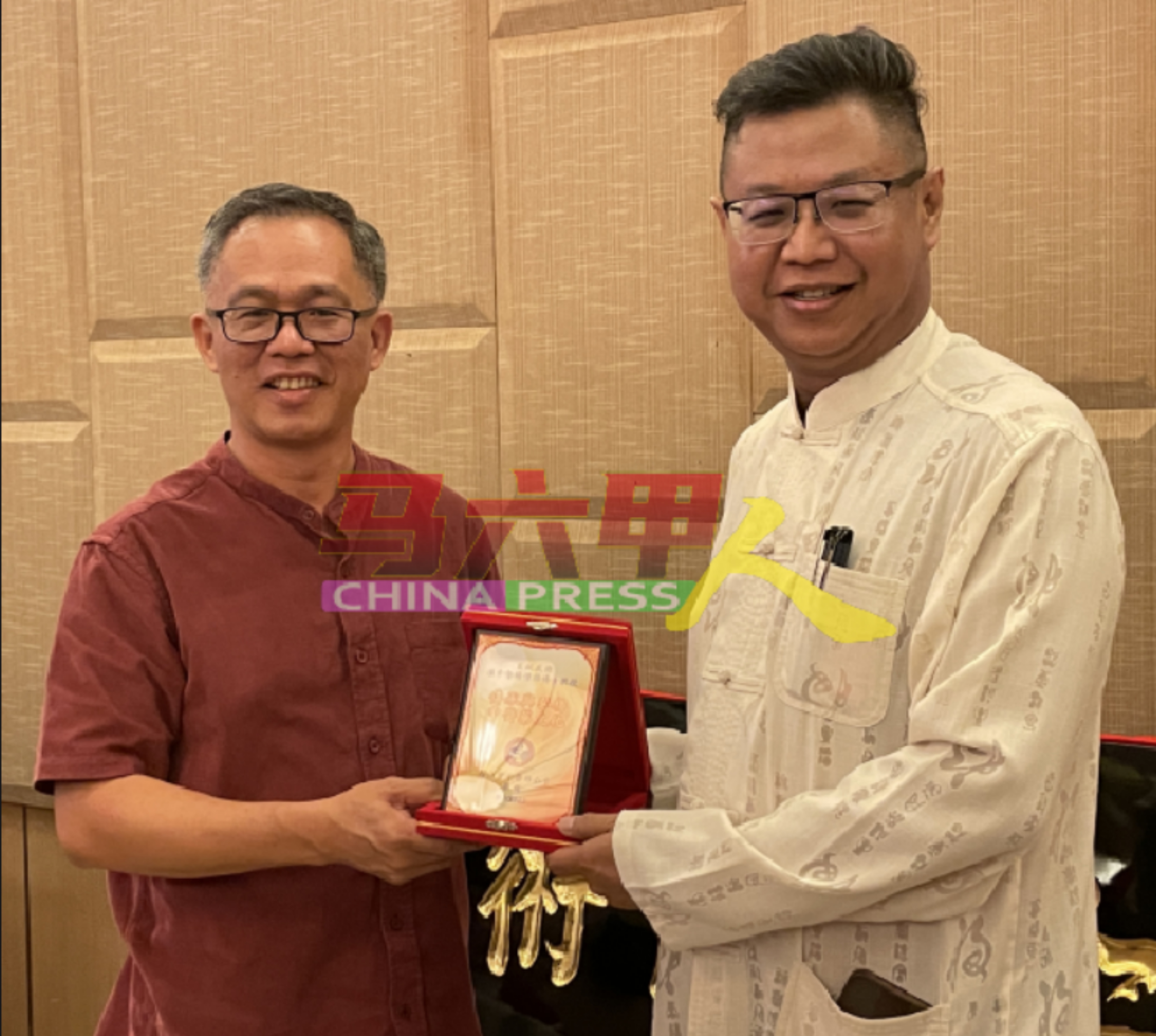 刘志俍（左起）颁发表彰盾，给施诊所义诊医师团队成员之一的杨伟雄。