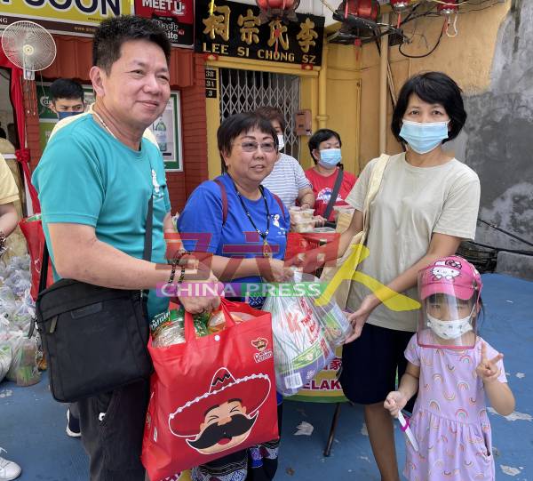 林福成（左起）和苏妙音，代表移交物资及红包给其中一户受惠家庭。