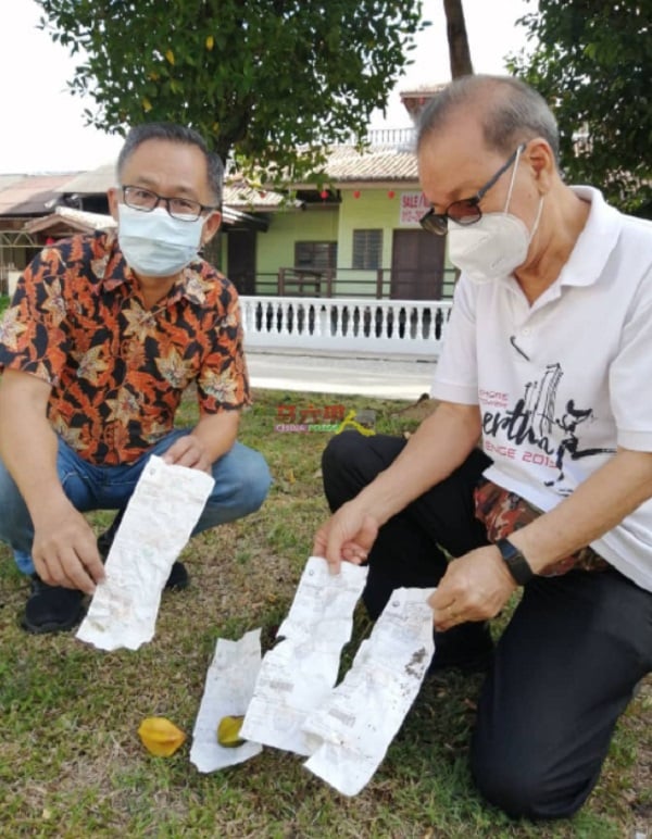 刘志俍（左起）与李祥生，在草堆找到被人丢弃的4张违规泊车罚单。