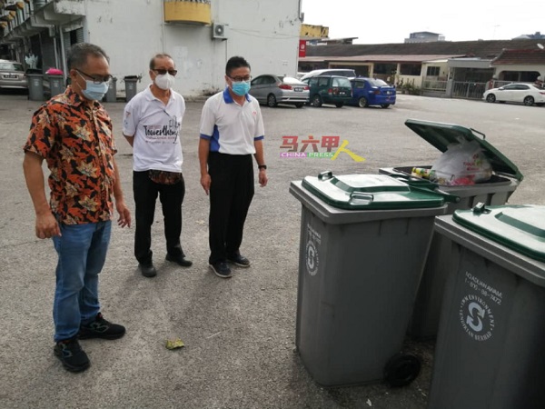 刘志俍（左起）、李祥生与杨先生，查看放在公寓楼下的垃圾桶。
