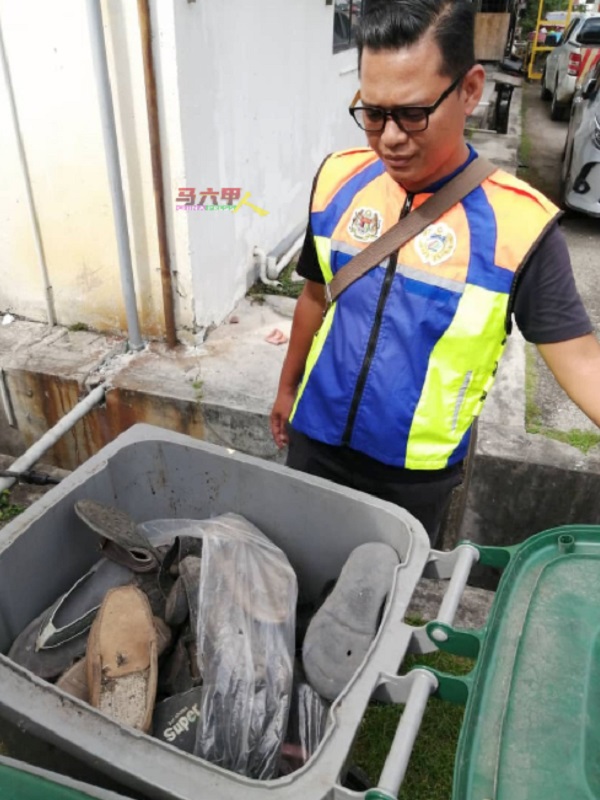 垃圾桶原本让居民扔厨余和生活垃圾，但却被滥用丢弃一大堆旧鞋，执法人员看了也无奈。