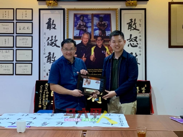 颜天禄（左）赠送纪念品予清华大学研究生骨干东南亚实践支队，由胡明远接领。