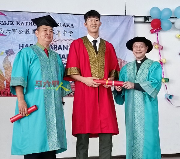 ■张德福神父（右）在赖水和（左）陪同下，颁发毕业证书给中五毕业生。