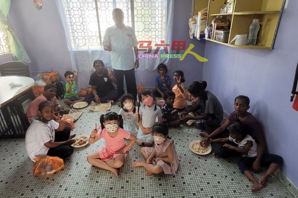 华裔家庭到访儿童之家及赞助午餐，他们的孩子（图中）也坐下与中心孩童交流。