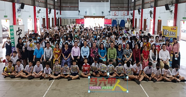 ■受惠学生开心地举起《中国报》，与嘉宾们合照。