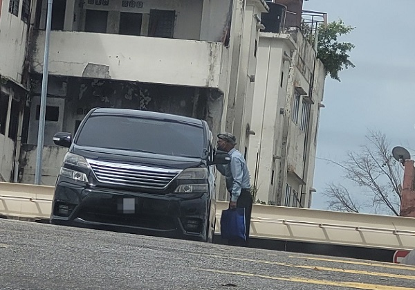 华裔老翁在路中拦停车辆讨钱，引起关注。