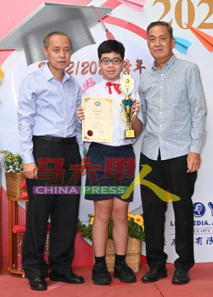 宋德祥（右起）颁发全校模范生奖给蔡祟彦。左是郑国华。