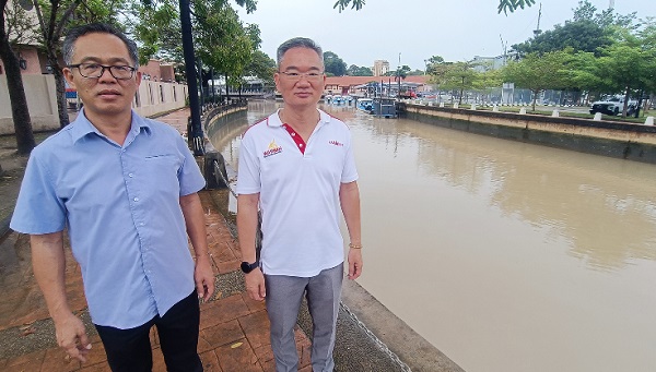 刘志俍（左）及邱培栋巡视马六甲河口的水位。