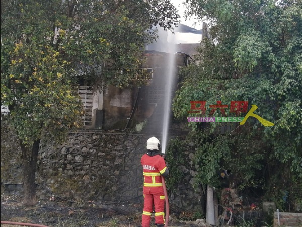 消拯员向工厂喷水灭火和降温。