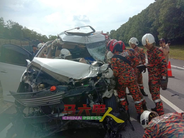 数名消拯员合力撬开撞毁的丰田VELLFIRE车门。（图消拯局提供）