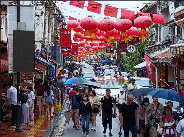 大雨也浇不熄游客到访马六甲的热情，雨天的鸡场街文化坊依然人气爆灯。