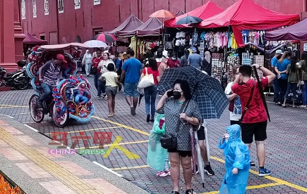大人撑伞，小朋友穿雨衣，大家游兴不减。