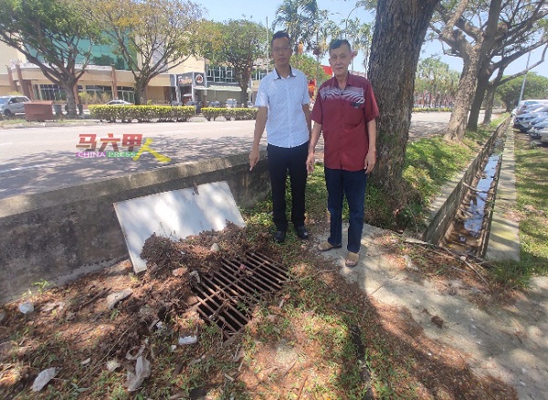 陈志成（右起）及罗舜生观察已十多年未清理的排洪沟。