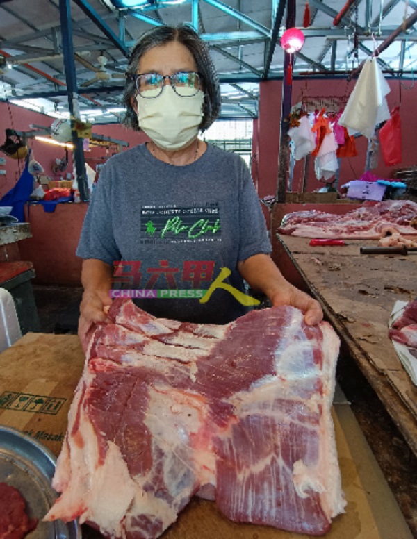 ■简太太拿着猪肉摊所售卖的三层肉。