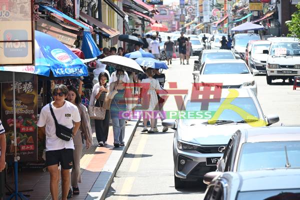 炎热天气，也无法阻挡来自国内外游客撑伞游古城。