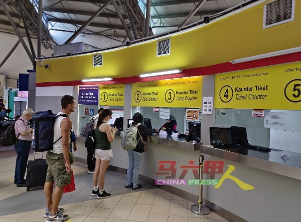 通过线上购票回乡的乘客，受促提早抵达车站，以到柜枱打印实体车票。