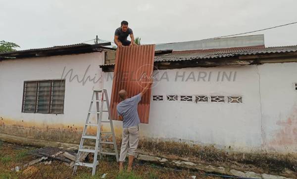 依万尤斯（下）担心暴风雨再次来袭，与家人、村民及当局协助下维修屋顶。