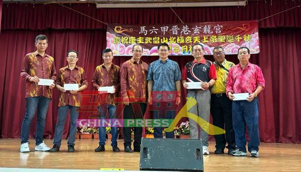 黄顺发（右 2）及刘庆保（左4起）在林万锋的见证下，移交捐款给各受惠团体。