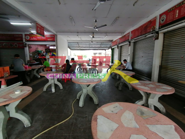 有外来人在清真摊位（右边摊）食用非清真食物，引起马来小贩非议。