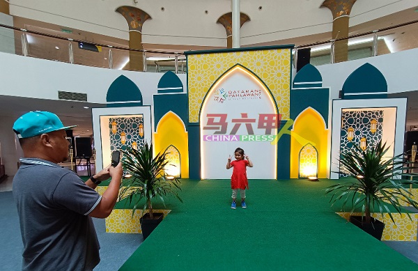 穆斯林同胞到访英雄广场时，不忘带孩子到开斋节舞台布景拍照。