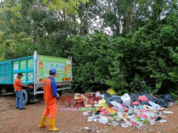 南方环保公司清理扔在义山的垃圾。