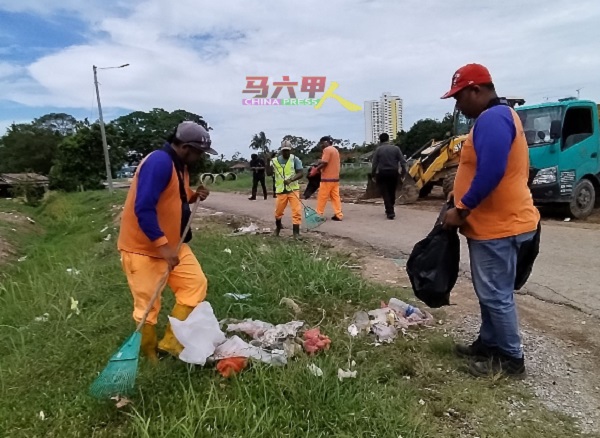 ■南方环保公司员工清扫散落在垃圾槽附近的垃圾。