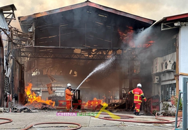 其中两名消拯员在厂内喷水灭火。