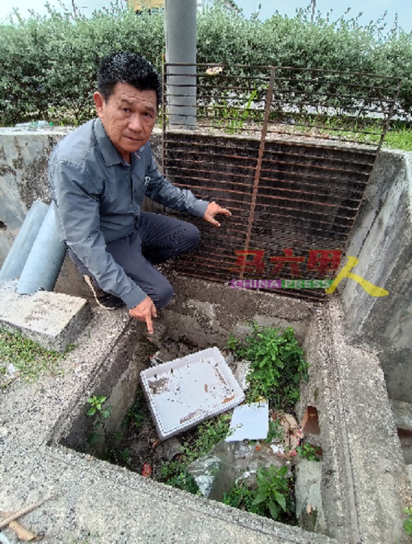 林千宏在其中一个沟盖可打开的沟渠里发现许多垃圾，沟渠已无法排水。