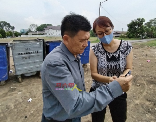杨女士（右起）播放坭机挖坑埋垃圾的视频，让林千宏了解情况。