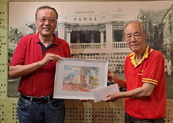 ■梁勇（左）赠新加坡华侨中学外观水彩画予沈墨义。