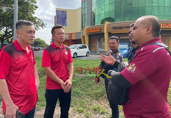 陈志成（左起）和罗舜生向甲州南方环保公司人员了解情况。