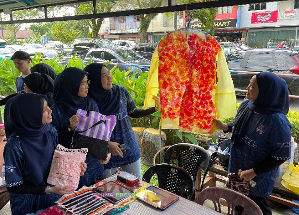学生们动一动脑筋和巧手，以塑料袋制成一件防水塑料雨衣。