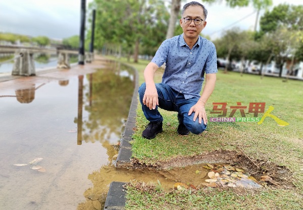 /■刘志俍察看市政厅新挖的临时出水口，发现功效不大。