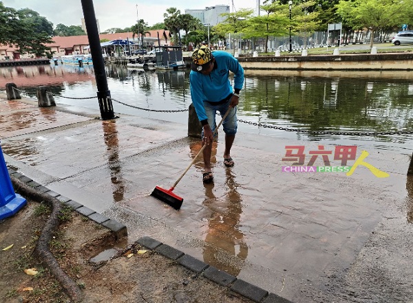 ■市政厅安排承包商在雨后清扫走道上的积水。