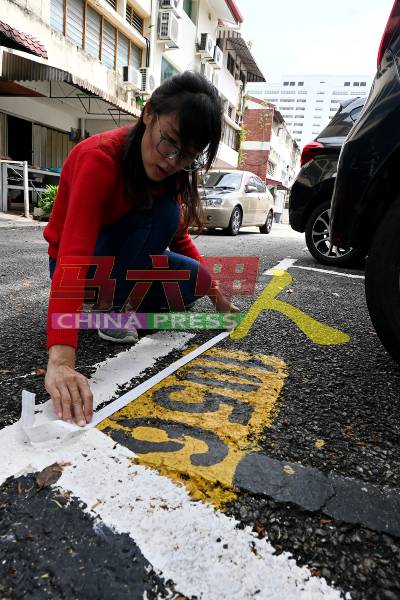 骆慧茹当场亲自测量泊车格的宽度。