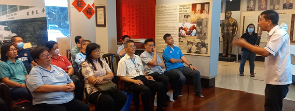 刘荣禧（右）向国民型华文中学校长们介绍沈慕羽书法文物馆内涵。