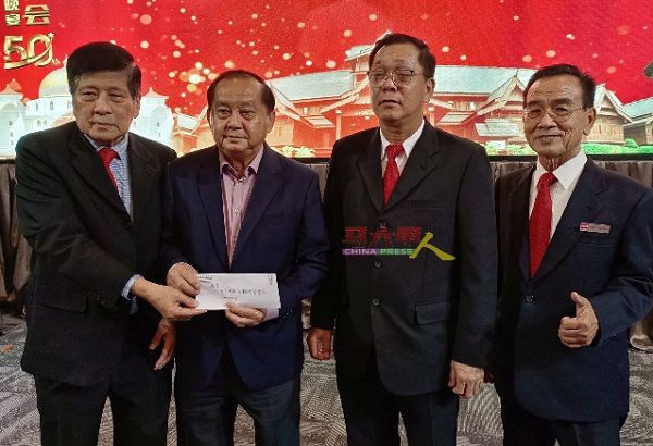 陈添财（左）、黄德伦（右起）及王天财代表甲车商公会移交捐款给峇章慈善基金会，由颜贞强接领。