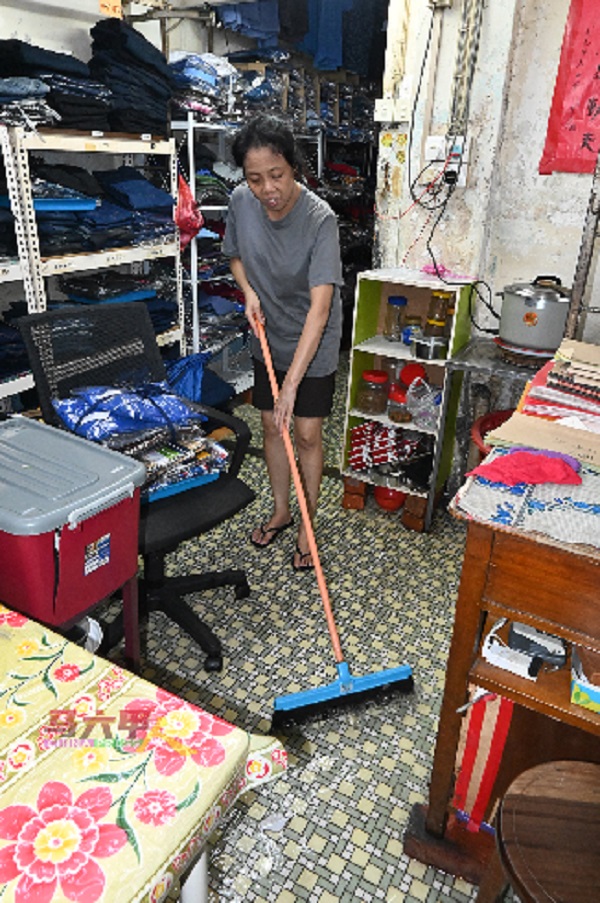 雨水消退后，店员忙于清理店内。