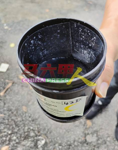 刘志俍出示诱蚊罐，里面装有清水，罐壁贴上黏着剂，以捕捉黑斑蚊。