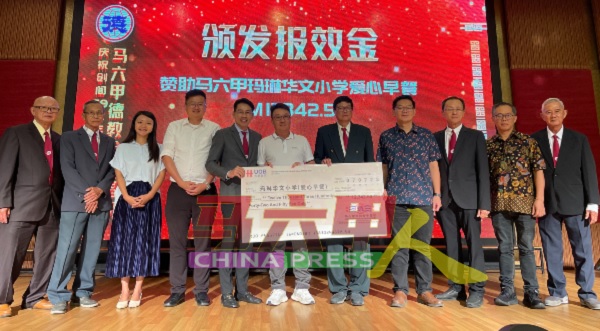 方光国（左6）代表玛琳华小副董事长黄守群，接领1万2342令吉50仙令吉模拟支票。
